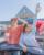 Two individuals standing out of a car sunroof with a Dutch Bros in hand